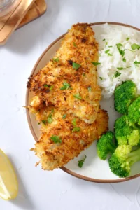 Air fryer walleye on a plate with green parsley on top.