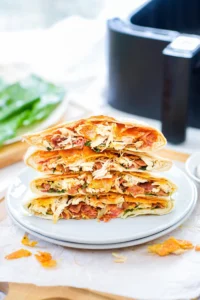 Close up of four stacked crunchwraps on a white plate.